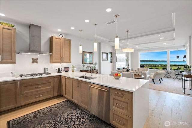 4907 Main St Unit 107, Tacoma, WA 98407 - kitchen featuring wall chimney range hood, stainless steel appliances, a sink, a peninsula, and a raised ceiling