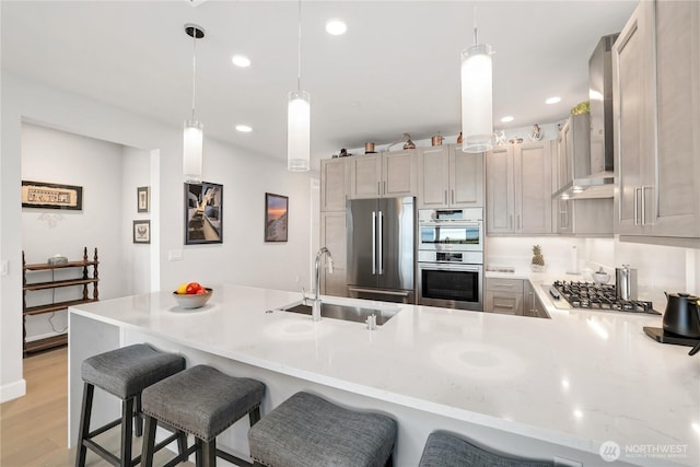 4907 Main St Unit 107, Tacoma, WA 98407 - kitchen featuring stainless steel appliances, a sink, wall chimney exhaust hood, a peninsula, and recessed lighting