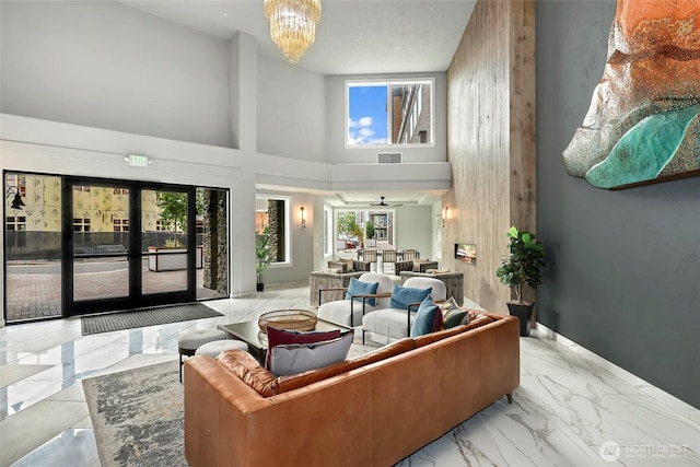 4907 Main St Unit 107, Tacoma, WA 98407 - living room with marble finish flooring, a chandelier, a towering ceiling, and baseboards