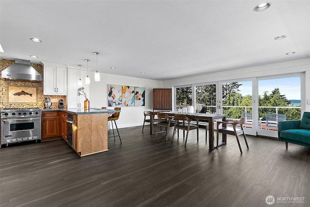 5758 Overlook Ave NE, Tacoma, WA 98422 - kitchen featuring designer range, wall chimney exhaust hood, a breakfast bar, a peninsula, and dark wood-style flooring