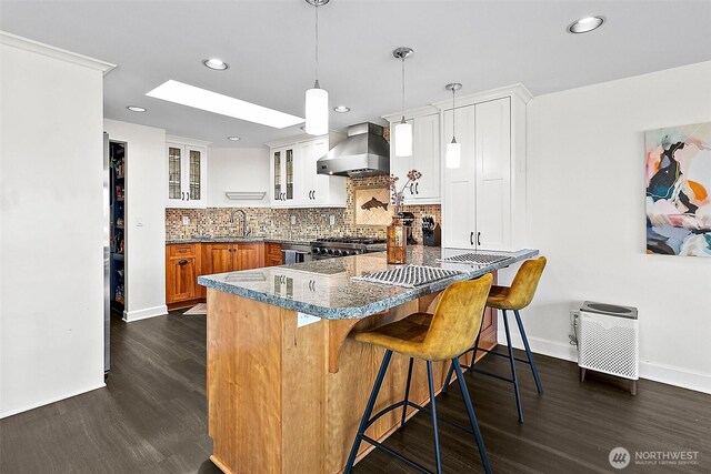 5758 Overlook Ave NE, Tacoma, WA 98422 - kitchen with wall chimney exhaust hood, dark wood-style flooring, stove, a kitchen breakfast bar, and glass insert cabinets