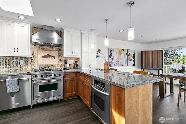 5758 Overlook Ave NE, Tacoma, WA 98422 - kitchen featuring appliances with stainless steel finishes, wall chimney range hood, a peninsula, dark wood finished floors, and a skylight