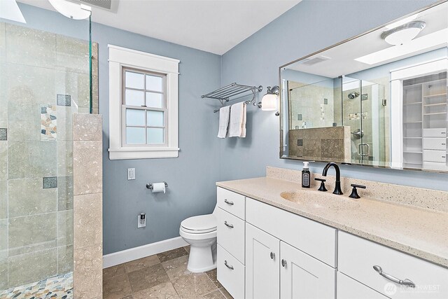 5758 Overlook Ave NE, Tacoma, WA 98422 - bathroom with baseboards, a stall shower, vanity, toilet, and a spacious closet