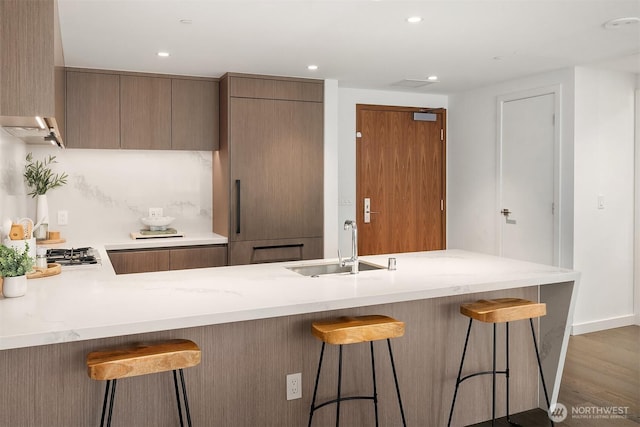 188 Bellevue Way NE Unit 307, Bellevue, WA 98004 - kitchen featuring a sink, light countertops, modern cabinets, a kitchen bar, and a peninsula