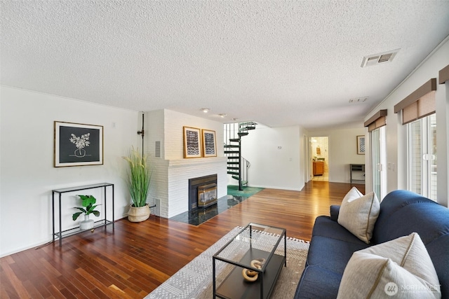 35029 37th Ave S, Auburn, WA 98001 - living room with a textured ceiling, plenty of natural light, wood finished floors, and a fireplace with flush hearth