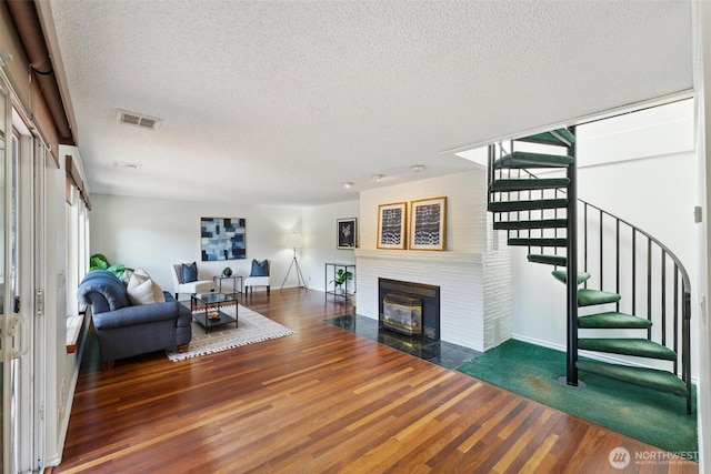 35029 37th Ave S, Auburn, WA 98001 - living area with a textured ceiling, a tile fireplace, wood finished floors, and stairway