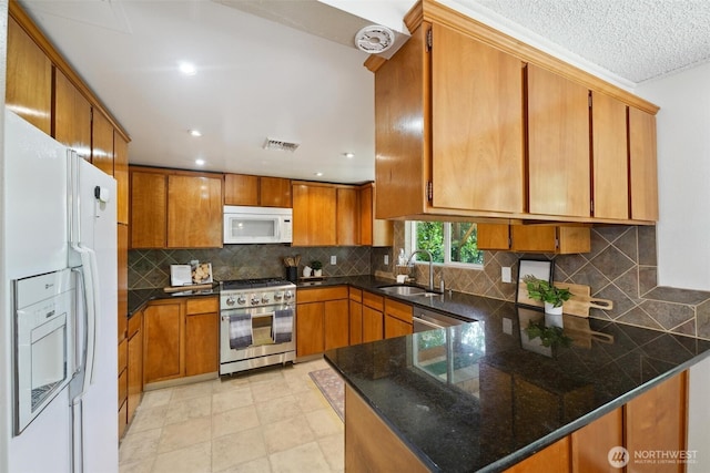 35029 37th Ave S, Auburn, WA 98001 - kitchen featuring stainless steel appliances, a peninsula, brown cabinetry, tasteful backsplash, and recessed lighting