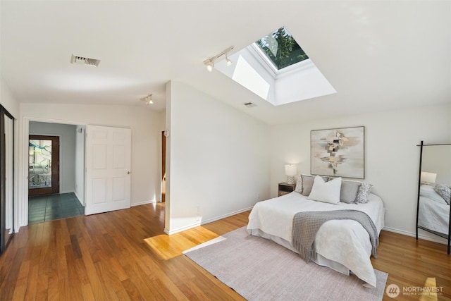 35029 37th Ave S, Auburn, WA 98001 - bedroom featuring a skylight, lofted ceiling, wood finished floors, multiple windows, and track lighting