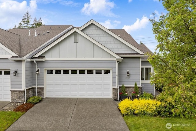 3707 Simmons Heights Ln SW, Tumwater, WA 98512 - craftsman-style home with stone siding, an attached garage, concrete driveway, and board and batten siding