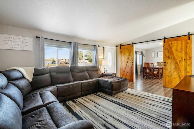 3327 Firouzi Dr NE, Moses Lake, WA 98837 - living area featuring a barn door, lofted ceiling, and light wood-style flooring