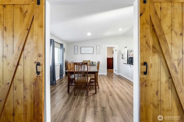 3327 Firouzi Dr NE, Moses Lake, WA 98837 - dining space with a barn door, lofted ceiling, wood finished floors, baseboards, and recessed lighting