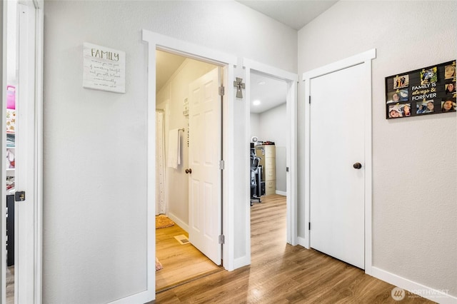 3327 Firouzi Dr NE, Moses Lake, WA 98837 - hallway featuring wood finished floors, water heater, and baseboards