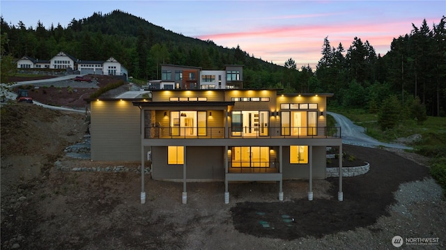 20519 Benson Ridge Ln, Mount Vernon, WA 98274 - back of property at dusk with a view of trees, a balcony, and a mountain view