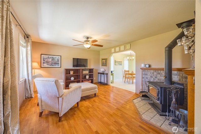 1160 Cays Rd, Sequim, WA 98382 - living area with wood finished floors, a wood stove, ceiling fan, and a chandelier