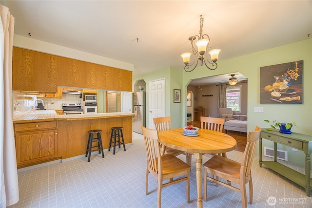 1160 Cays Rd, Sequim, WA 98382 - dining area featuring arched walkways, a chandelier, and ceiling fan