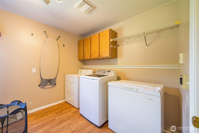 1160 Cays Rd, Sequim, WA 98382 - laundry area featuring cabinet space, washing machine and clothes dryer, light wood-style floors, and baseboards