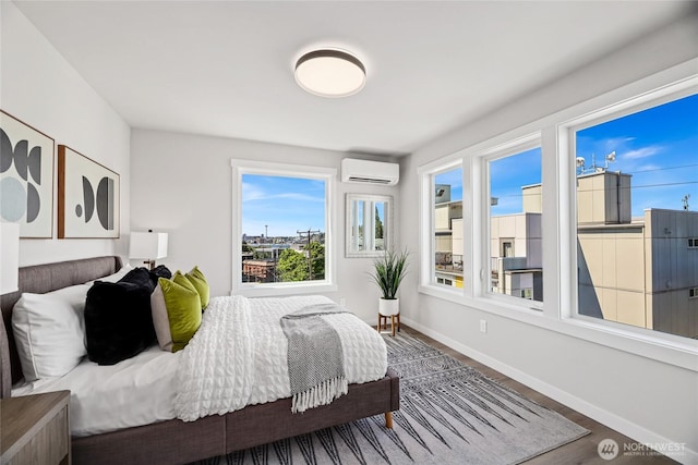 2817 Franklin Ave E Unit A, Seattle, WA 98102 - bedroom featuring an AC wall unit, wood finished floors, and baseboards