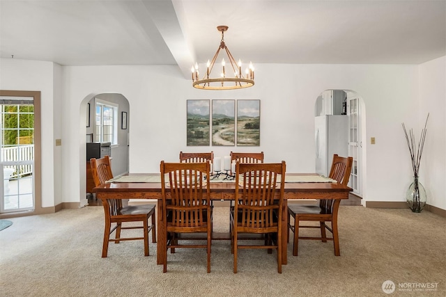 10918 159th Ave SE, Snohomish, WA 98290 - dining space with arched walkways, light colored carpet, a chandelier, and baseboards