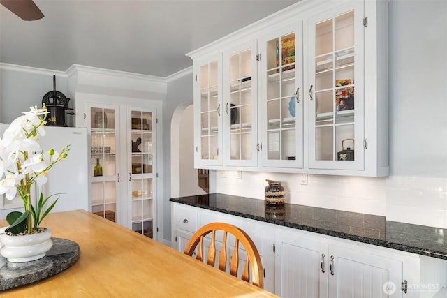 10918 159th Ave SE, Snohomish, WA 98290 - kitchen with white cabinetry, glass insert cabinets, decorative backsplash, and arched walkways