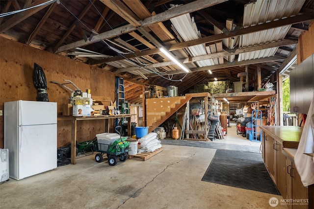 10918 159th Ave SE, Snohomish, WA 98290 - garage featuring freestanding refrigerator, a workshop area, and wooden walls