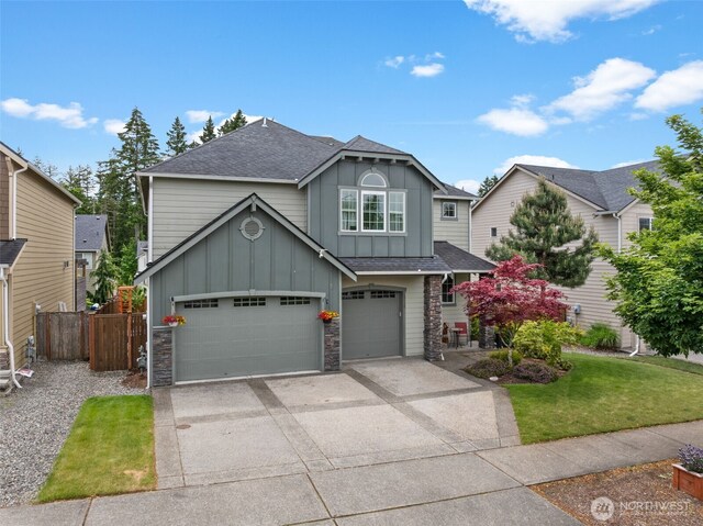 4415 Goldcrest Dr NW, Olympia, WA 98502 - view of front of property featuring board and batten siding, concrete driveway, stone siding, a shingled roof, and a garage