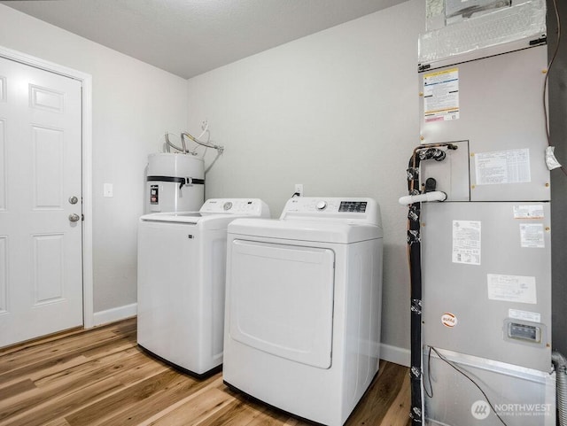 13576 NE Rd 10, Moses Lake, WA 98837 - laundry area with separate washer and dryer, water heater, heating unit, light wood finished floors, and baseboards