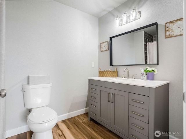 13576 NE Rd 10, Moses Lake, WA 98837 - full bath with wood finished floors, toilet, baseboards, and vanity