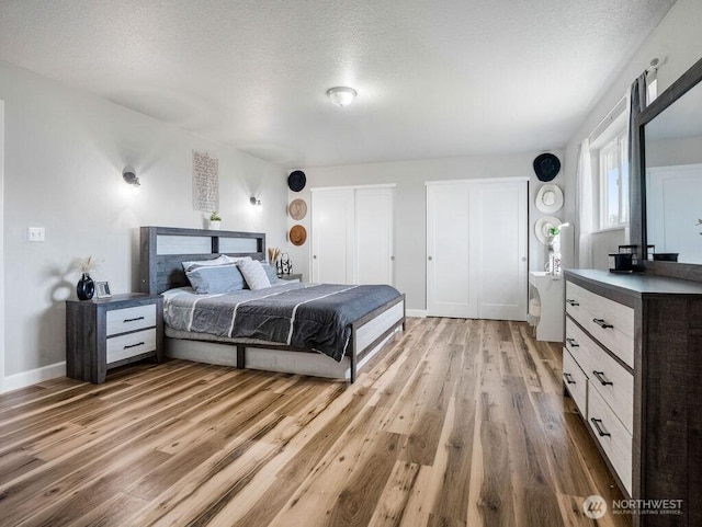13576 NE Rd 10, Moses Lake, WA 98837 - bedroom featuring two closets, light wood finished floors, a textured ceiling, and baseboards