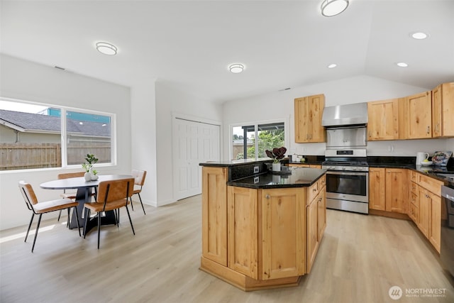 8010 Beverly Blvd Unit A, Everett, WA 98203 - kitchen featuring stainless steel gas stove, wall chimney range hood, a kitchen island, light wood-style floors, and dark stone countertops