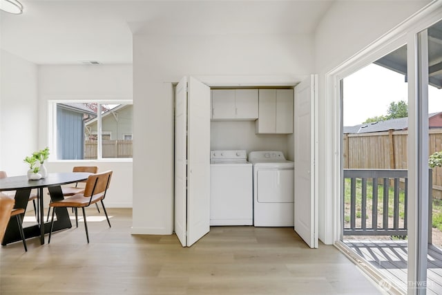 8010 Beverly Blvd Unit A, Everett, WA 98203 - washroom featuring cabinet space, healthy amount of natural light, light wood-style flooring, and separate washer and dryer