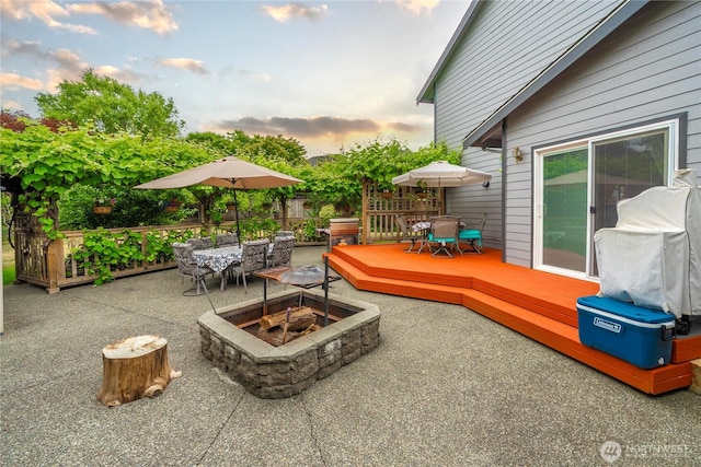 27772 213th Ct SE, Maple Valley, WA 98038 - patio terrace at dusk with an outdoor fire pit, outdoor dining space, a deck, a patio, and area for grilling