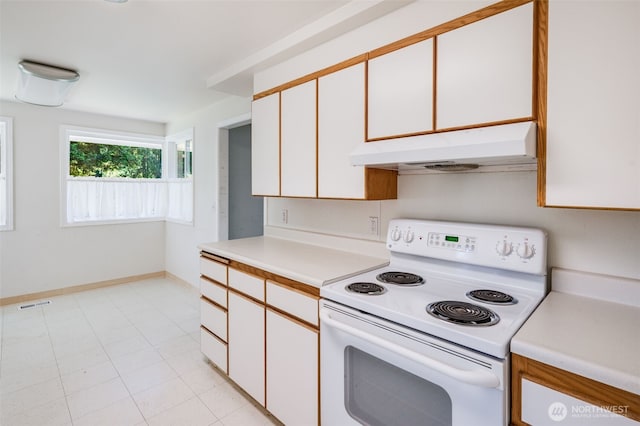 11319 86th Ave E, Puyallup, WA 98373 - kitchen with white range with electric cooktop, under cabinet range hood, light countertops, white cabinets, and baseboards