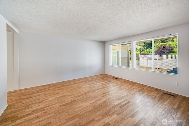 11319 86th Ave E, Puyallup, WA 98373 - unfurnished room featuring light wood-style flooring, a textured ceiling, and baseboards