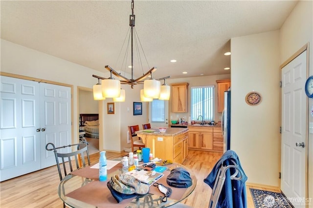 152 N Oar Loop NW, Ocean Shores, WA 98569 - dining room featuring light wood-style flooring, recessed lighting, a textured ceiling, and baseboards