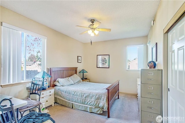152 N Oar Loop NW, Ocean Shores, WA 98569 - bedroom featuring light carpet, multiple windows, a ceiling fan, and baseboards