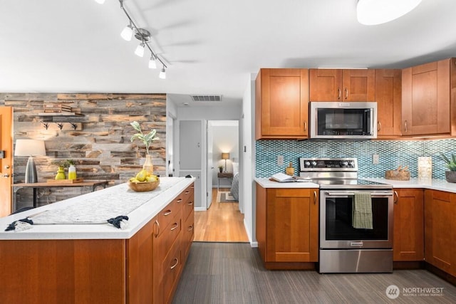8414 34th Ave SW, Seattle, WA 98126 - kitchen with appliances with stainless steel finishes, light countertops, brown cabinetry, and decorative backsplash