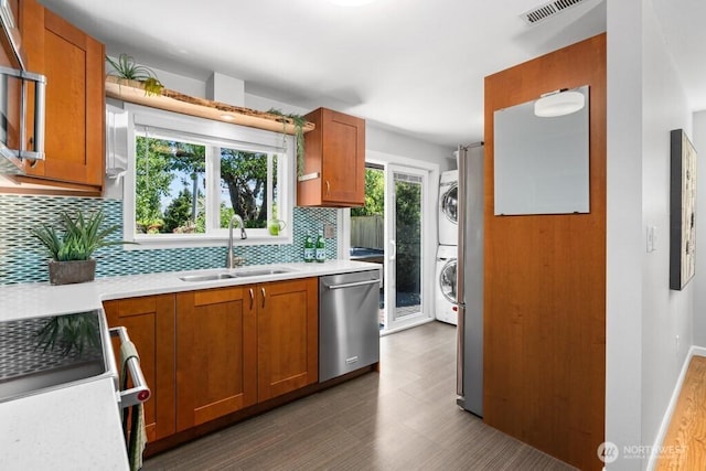 8414 34th Ave SW, Seattle, WA 98126 - kitchen with dishwasher, stacked washing machine and dryer, a sink, tasteful backsplash, and stove