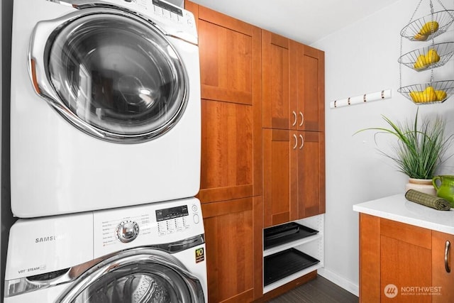 8414 34th Ave SW, Seattle, WA 98126 - laundry room featuring estacked washer and dryer, cabinet space, baseboards, and dark wood-style floors