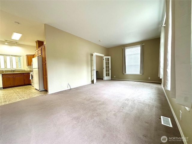 173 Steelhead Dr, Silver Creek, WA 98585 - unfurnished living room featuring light colored carpet, a sink, baseboards, and french doors
