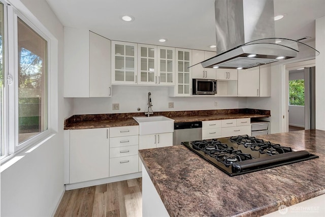 19055 SE 269th St, Covington, WA 98042 - kitchen with island exhaust hood, appliances with stainless steel finishes, a sink, light wood finished floors, and white cabinets