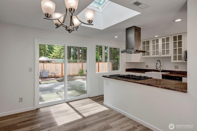 19055 SE 269th St, Covington, WA 98042 - kitchen with island range hood, white cabinetry, black gas cooktop, a skylight, and baseboards