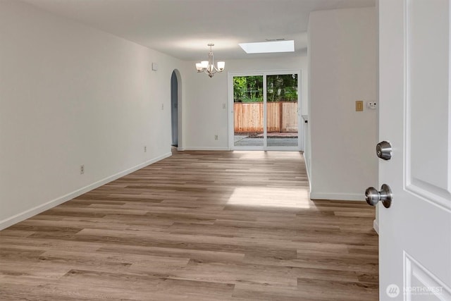 19055 SE 269th St, Covington, WA 98042 - spare room with arched walkways, a chandelier, wood finished floors, and baseboards