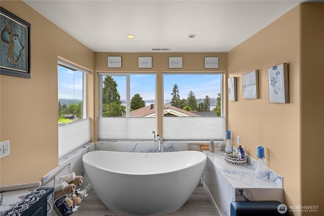 11031 Cornell Ave S, Seattle, WA 98178 - full bath featuring wood finished floors, a freestanding tub, and recessed lighting