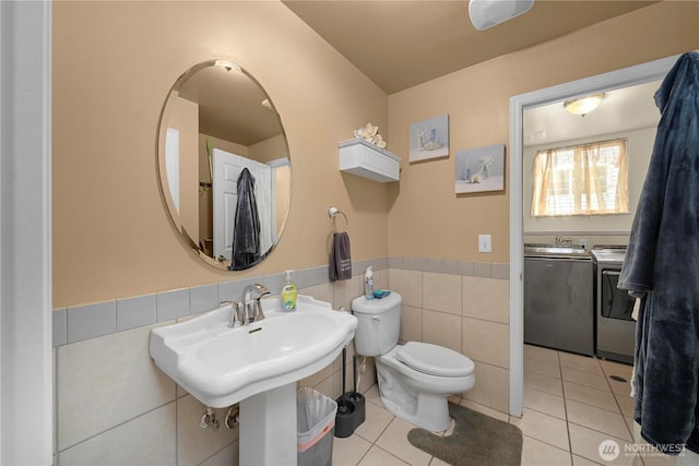 11031 Cornell Ave S, Seattle, WA 98178 - bathroom with washer and clothes dryer, tile patterned flooring, wainscoting, toilet, and tile walls