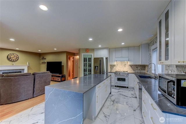 14531 86th Pl NE, Kenmore, WA 98028 - kitchen featuring appliances with stainless steel finishes, a center island, white cabinetry, light marble finish floors, and decorative backsplash