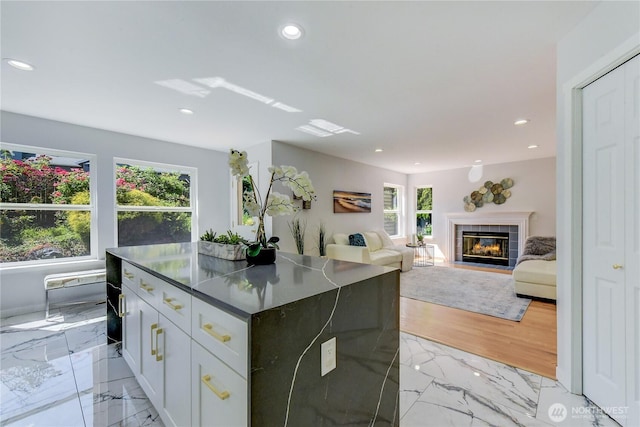 14531 86th Pl NE, Kenmore, WA 98028 - kitchen featuring light marble finish flooring, recessed lighting, a kitchen island, dark countertops, and a tiled fireplace