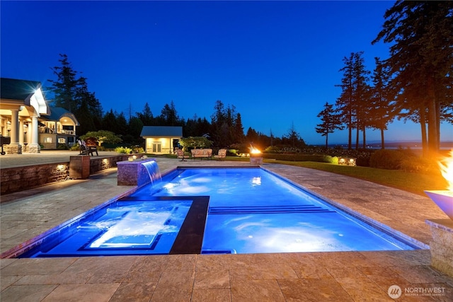 33020 84th Ave NW, Stanwood, WA 98292 - pool at night with a patio area, an outdoor structure, an exterior structure, and a pool with connected hot tub