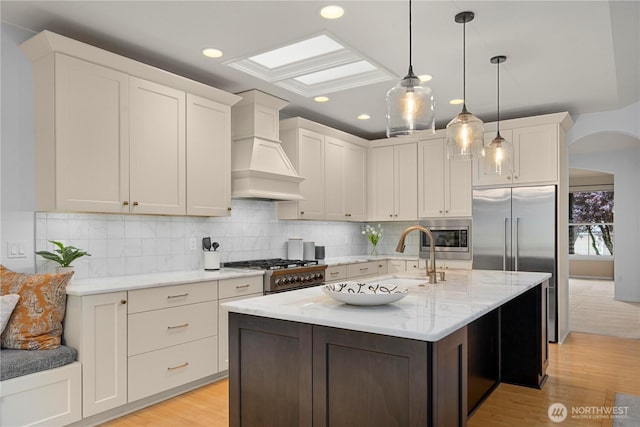 8122 104th Street Ct SW, Lakewood, WA 98498 - kitchen featuring premium range hood, built in appliances, light wood-style floors, backsplash, and recessed lighting