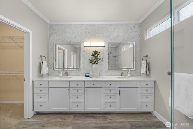 8122 104th Street Ct SW, Lakewood, WA 98498 - bathroom featuring ornamental molding, double vanity, a spacious closet, and wood finished floors
