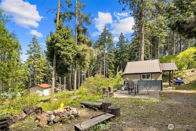 131 Horse Heaven Rd, Cle Elum, WA 98922 - view of yard with a fire pit, a patio, an outdoor structure, and a forest view